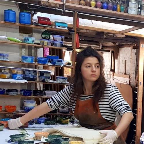 Poppy Purchase textile workshop A girl in a studio surrounded by paint pots